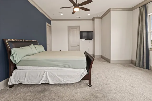 a spacious bedroom with a large bed and a chandelier