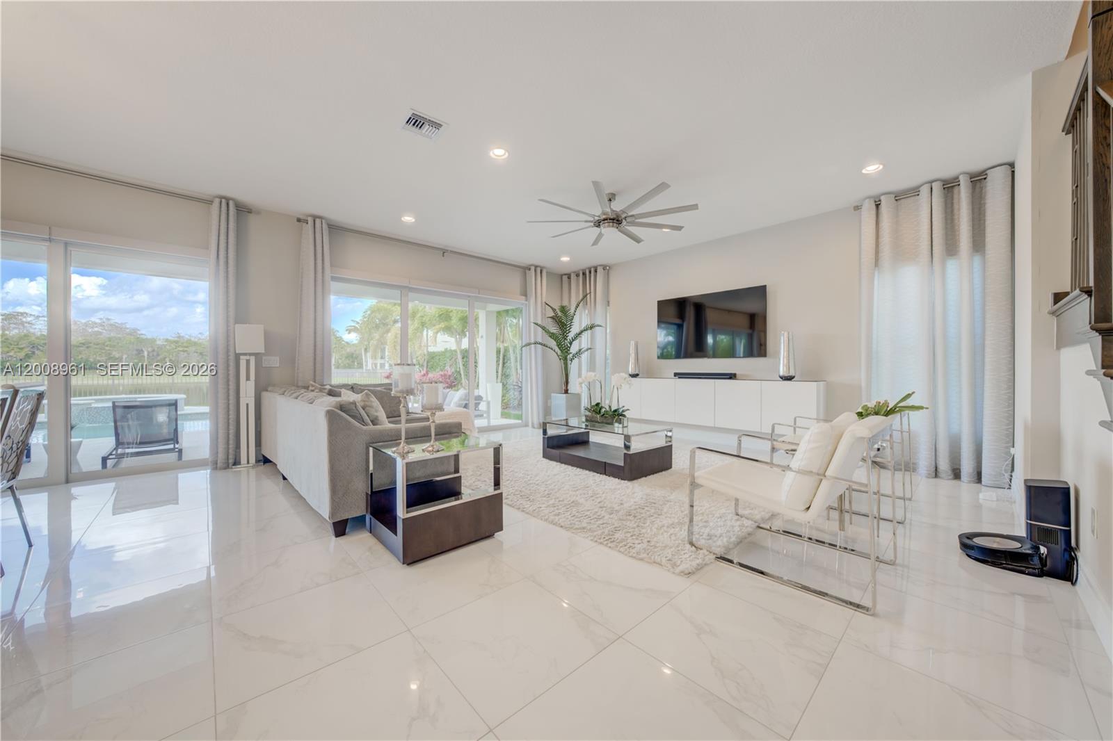 11655 Windy Frst Way Boca Raton, FL 33498 - Photo 15 of 47 a living room with furniture a flat screen tv and a large window