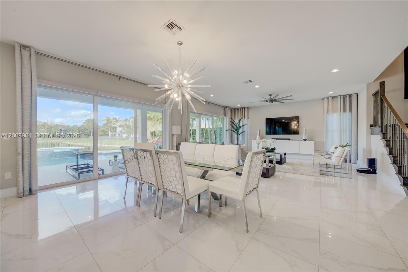 11655 Windy Frst Way Boca Raton, FL 33498 - Photo 24 of 47 a living room with furniture a flat screen tv and a large window