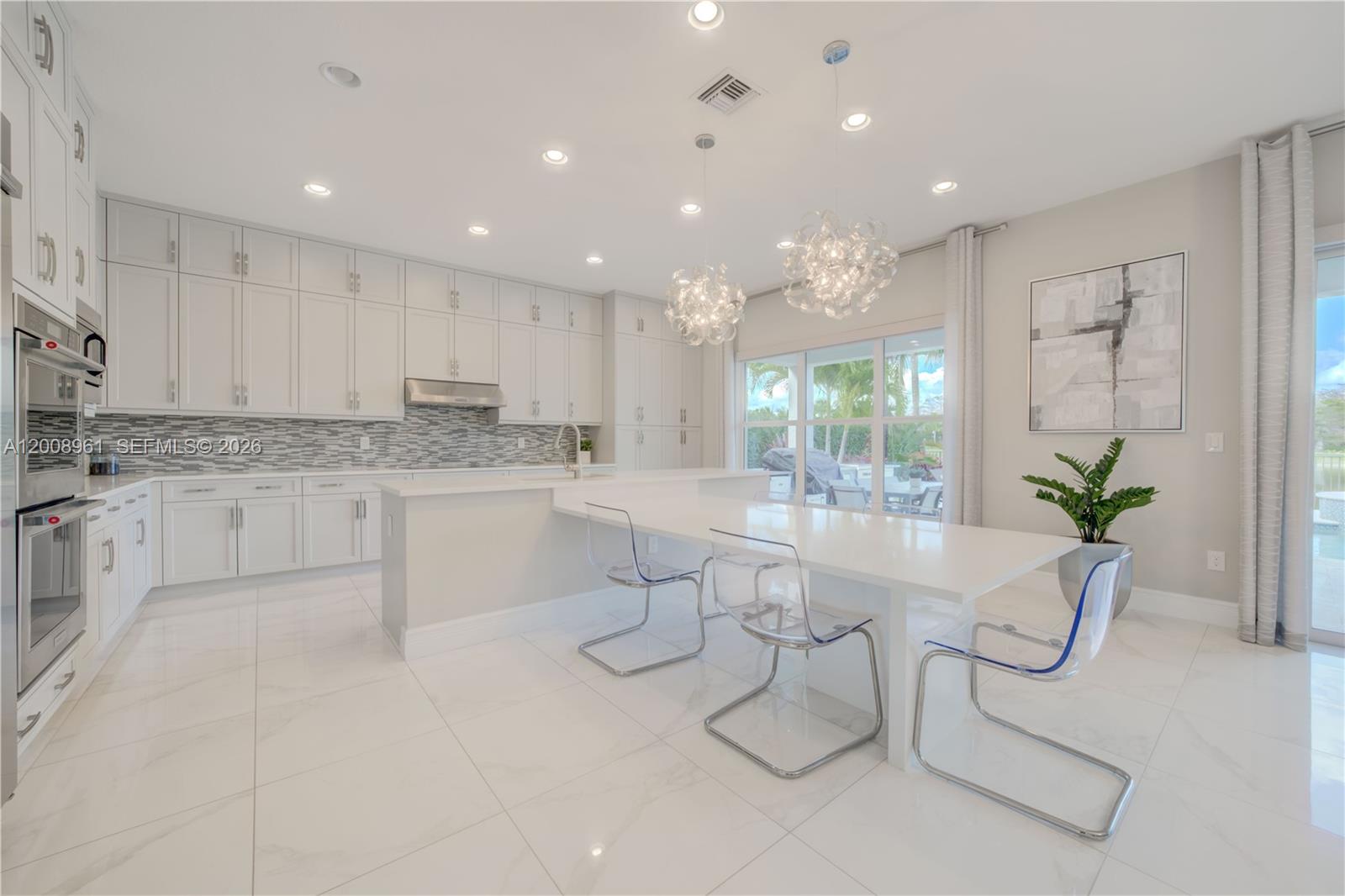 11655 Windy Frst Way Boca Raton, FL 33498 - Photo 3 of 47 a room with stainless steel appliances kitchen island granite countertop a sink and cabinets