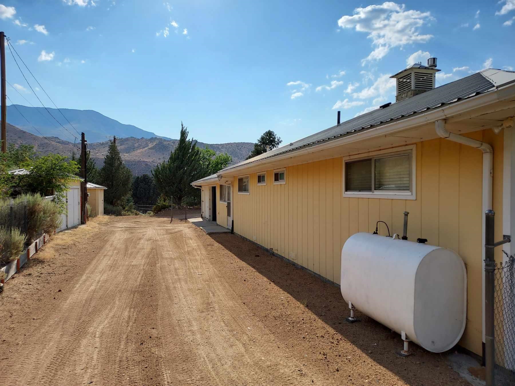 59 Dry Canyon Road Coleville, CA 96107 - Photo 3 of 15 View of front of home featuring a mountain view, a garage, a metal roof, and a chimney