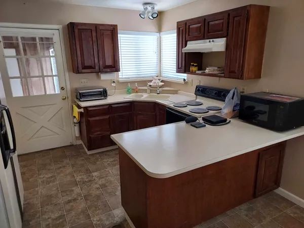 a kitchen with stainless steel appliances a stove a sink a microwave a refrigerator and cabinets
