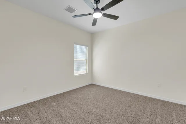 an empty room with chandelier fan