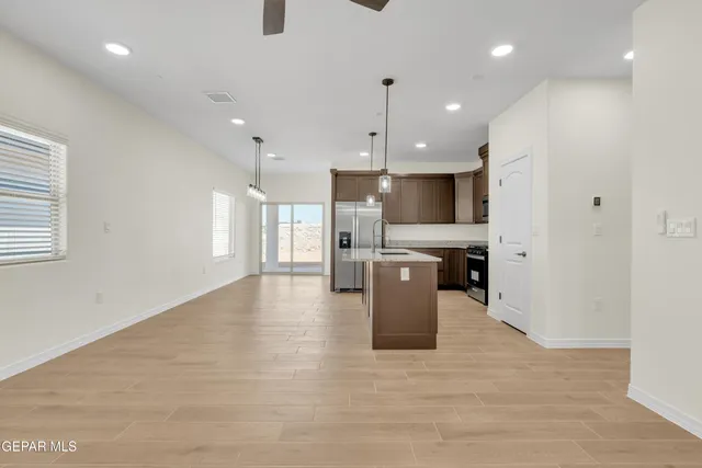 a kitchen with kitchen island a sink stainless steel appliances and cabinets