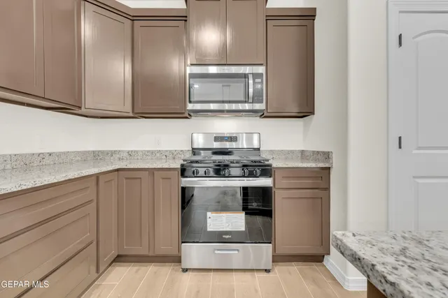 a bathroom with a granite countertop toilet a sink and a mirror