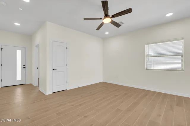 an empty room with wooden floor and windows