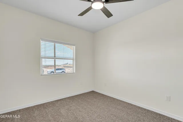 an empty room with a window and a fan