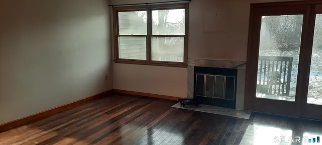 wooden floor in an empty room with a window