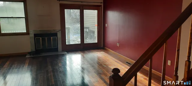a view of wooden floor in a hall with a window