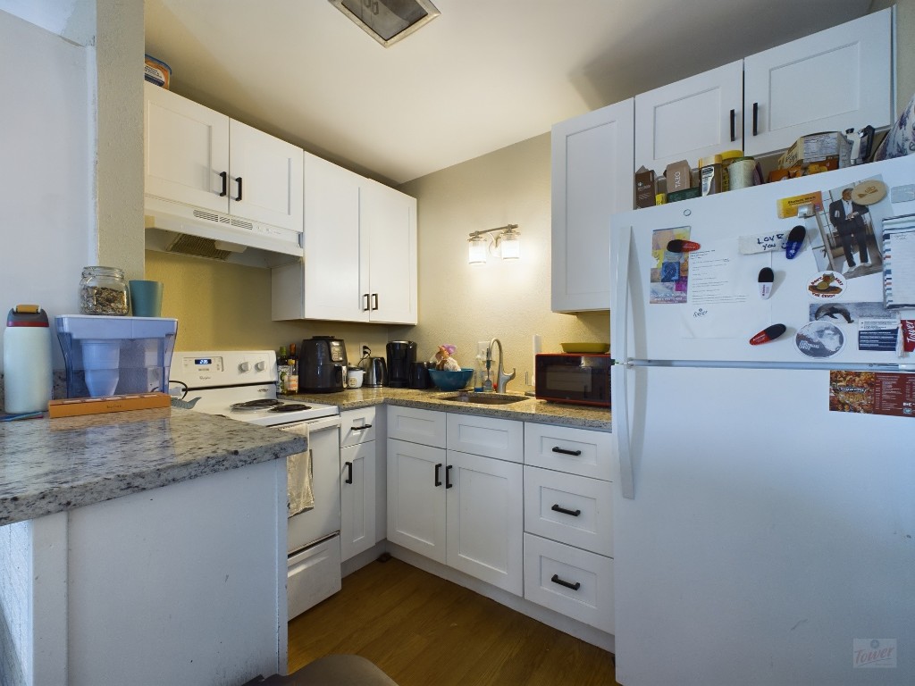 1000 West 26th Street, Unit 118 Austin, TX 78705 - Photo 12 of 18 a kitchen with cabinets appliances wooden floor and a window
