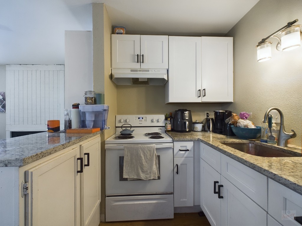 1000 West 26th Street, Unit 118 Austin, TX 78705 - Photo 13 of 18 a kitchen with granite countertop white cabinets and white appliances