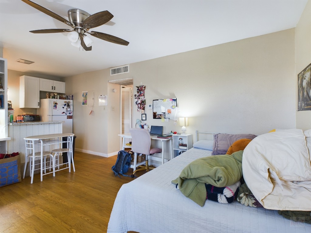 1000 West 26th Street, Unit 118 Austin, TX 78705 - Photo 6 of 18 a bedroom with furniture and a wooden floor