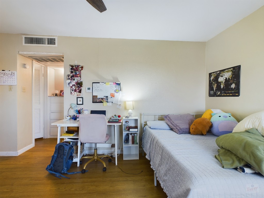 1000 West 26th Street, Unit 118 Austin, TX 78705 - Photo 8 of 18 a bedroom with a bed and wooden floor