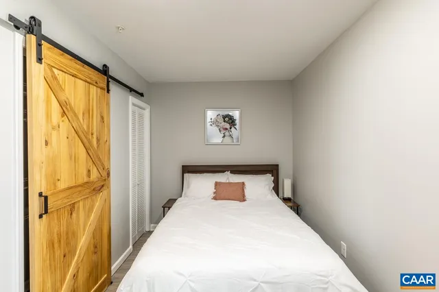 a bedroom with a bed and wooden floor