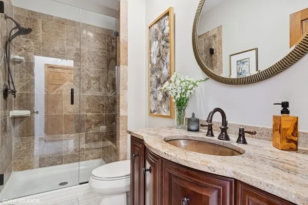 a bathroom with a granite countertop sink a toilet and a mirror