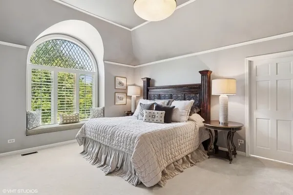 a bedroom with a bed and a large window