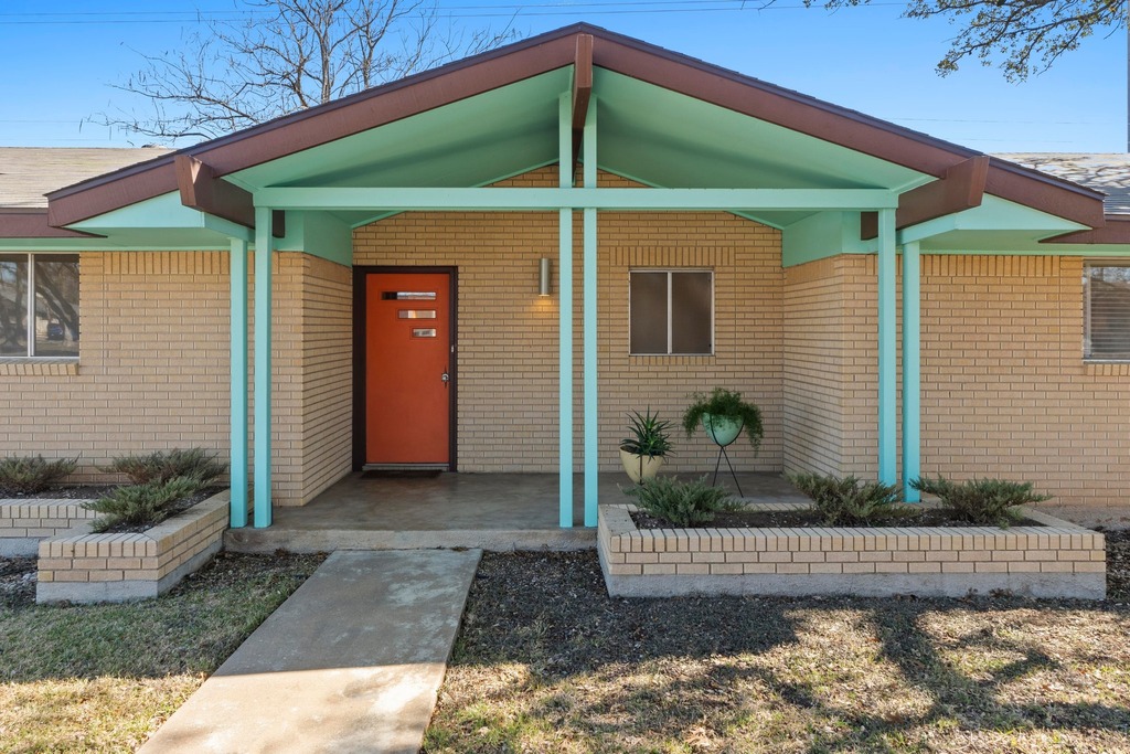 Property entrance with covered porch and brick siding