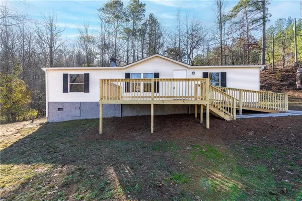 a view of a house with a yard and wooden fence