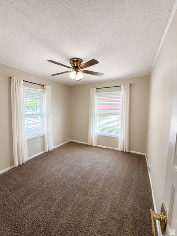1766 Kenilworth Road Spring Glen, UT 84526 - Photo 7 of 24 Carpeted interior room featuring a ceiling fan with integrated lighting, two windows with blinds and curtains, and neutral wall paint