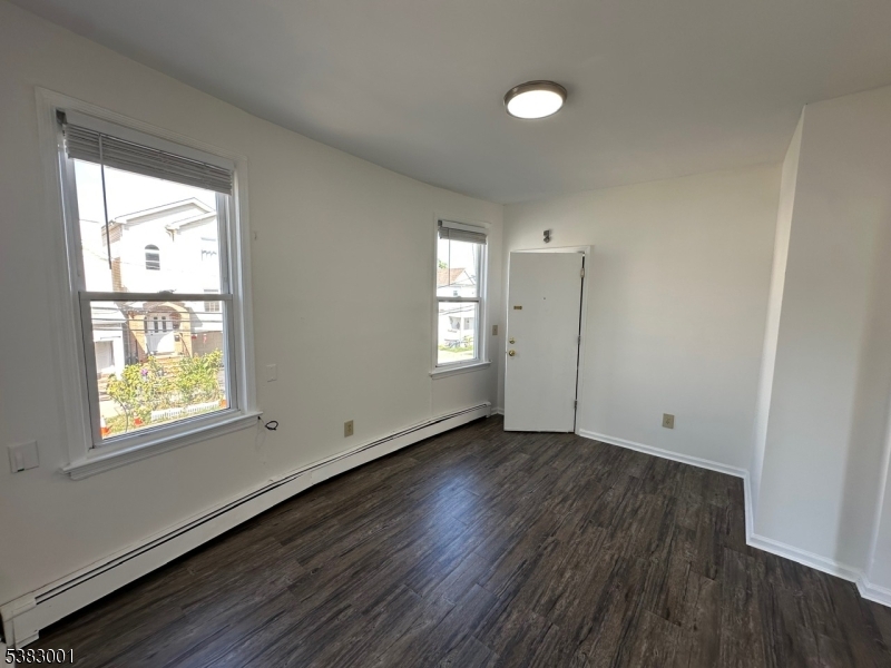 145 Smith Street, Unit 2F Elizabeth, NJ 07201 - Photo 10 of 17 an empty room with wooden floor and windows