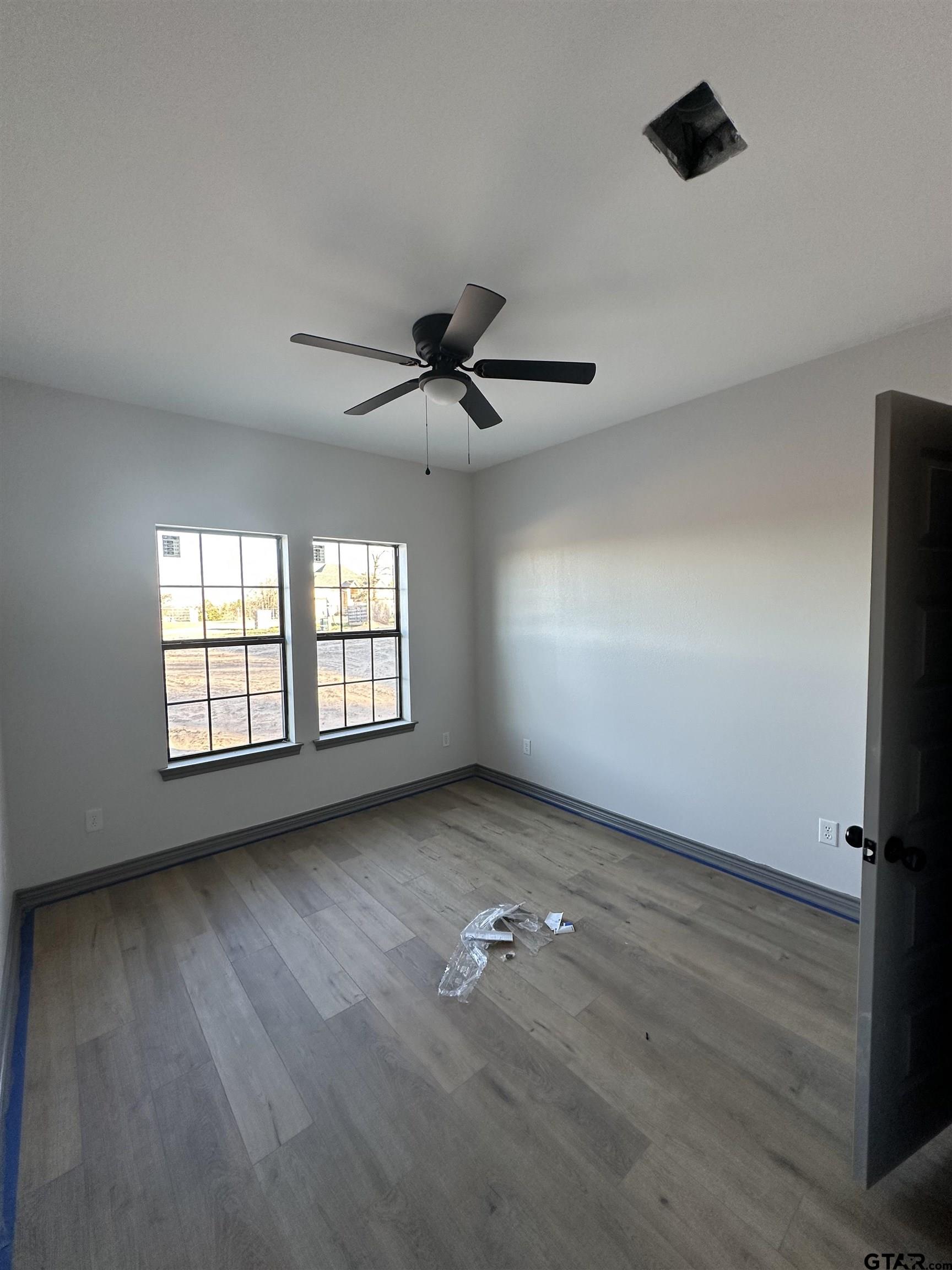 9839 County Road 35 Tyler, TX 75706 - Photo 4 of 12 an empty room with wooden floor fan and windows