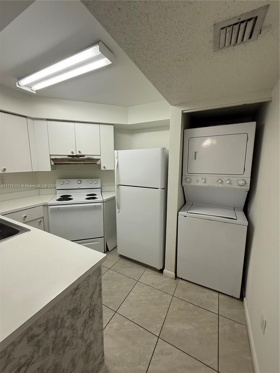 8335 Southwest 152nd Avenue, Unit B106 Miami, FL 33193 - Photo 17 of 27 a kitchen with a refrigerator sink and cabinets