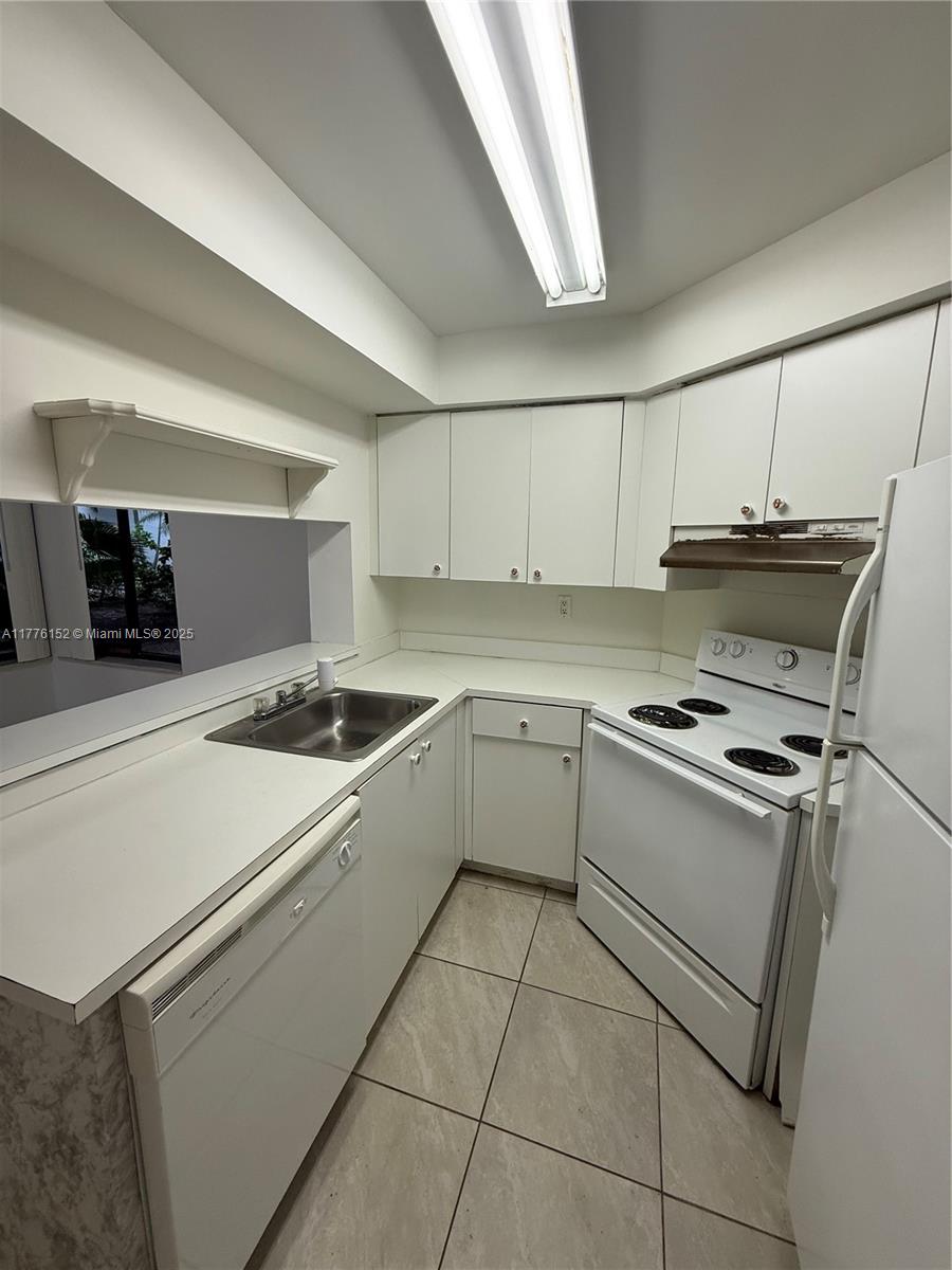8335 Southwest 152nd Avenue, Unit B106 Miami, FL 33193 - Photo 18 of 27 a kitchen with a stove a sink and a refrigerator