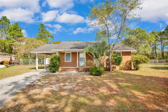 a view of a house with a yard and pathway