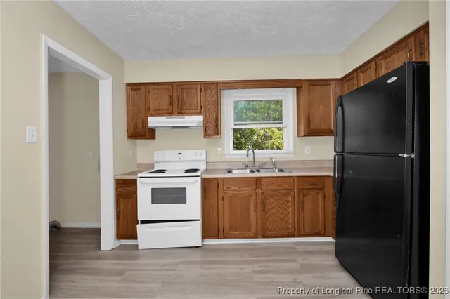 a kitchen with a refrigerator sink and cabinets