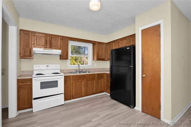 a kitchen with a refrigerator stove and sink