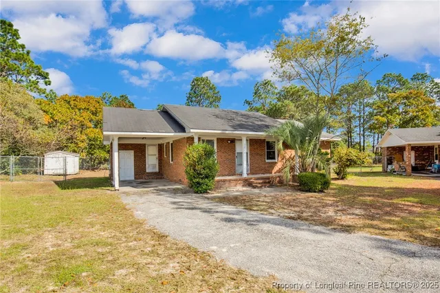 a front view of a house with a garden and trees