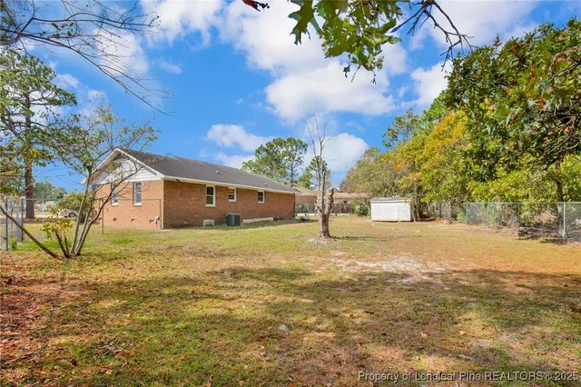 a view of a yard with plants and trees