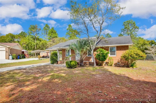 a view of a house with a yard and potted plants