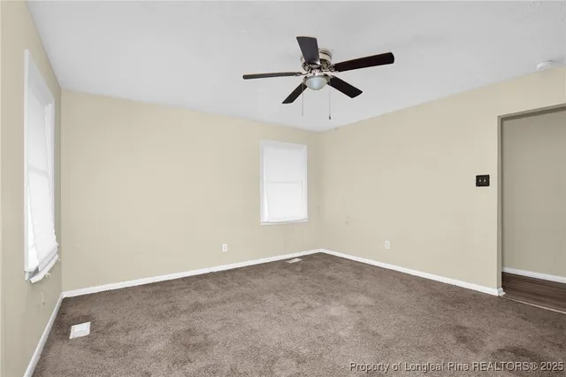 a view of a big room with carpet and windows