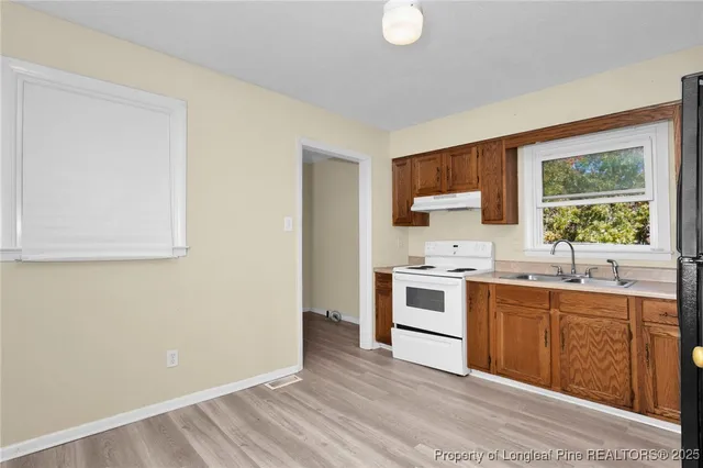a kitchen with a stove top oven sink and window