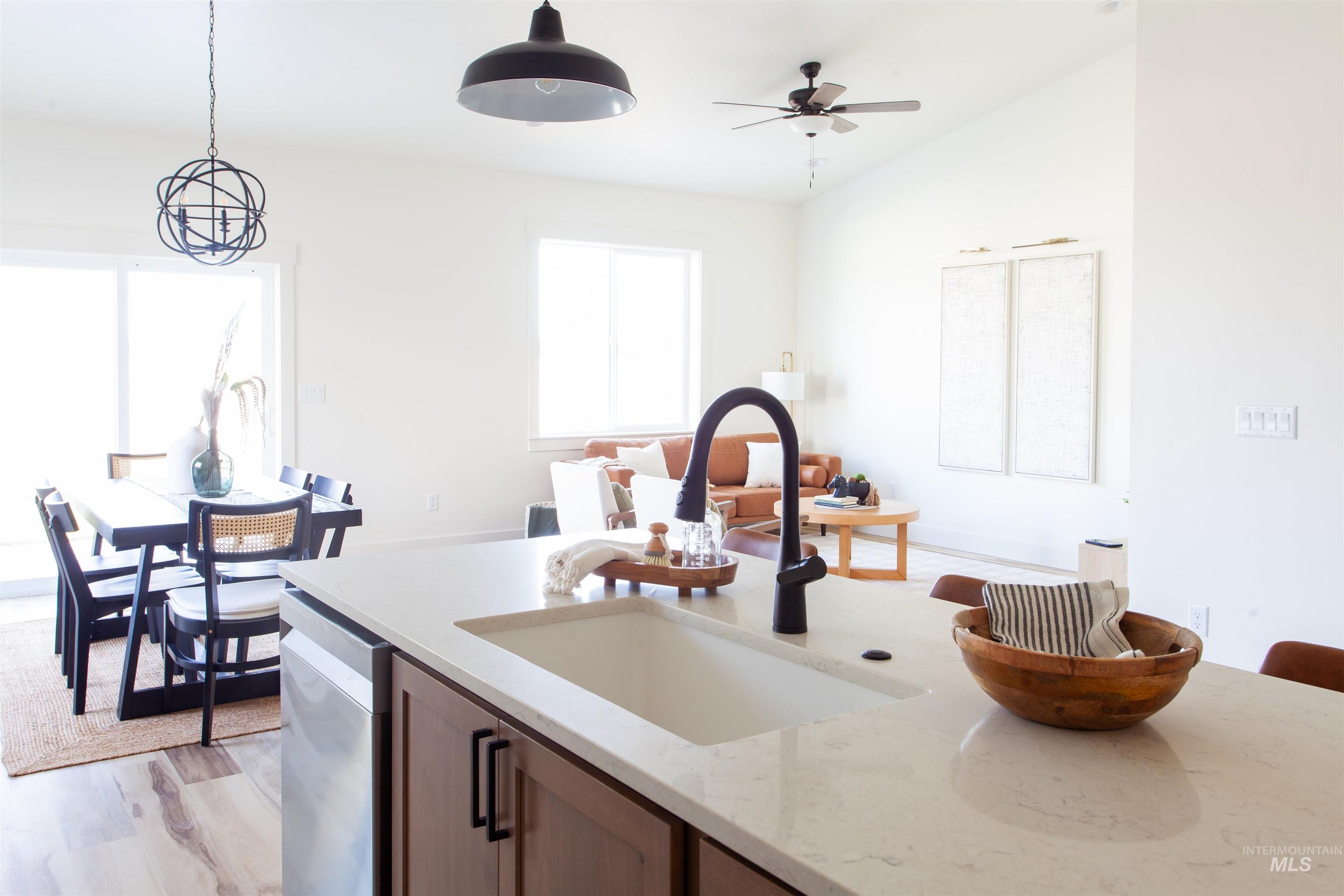 1113 Velvet Loop Wilder, ID 83676 - Photo 13 of 29 Kitchen featuring light stone countertops, pendant lighting, light wood-style flooring, ceiling fan, and stainless steel dishwasher