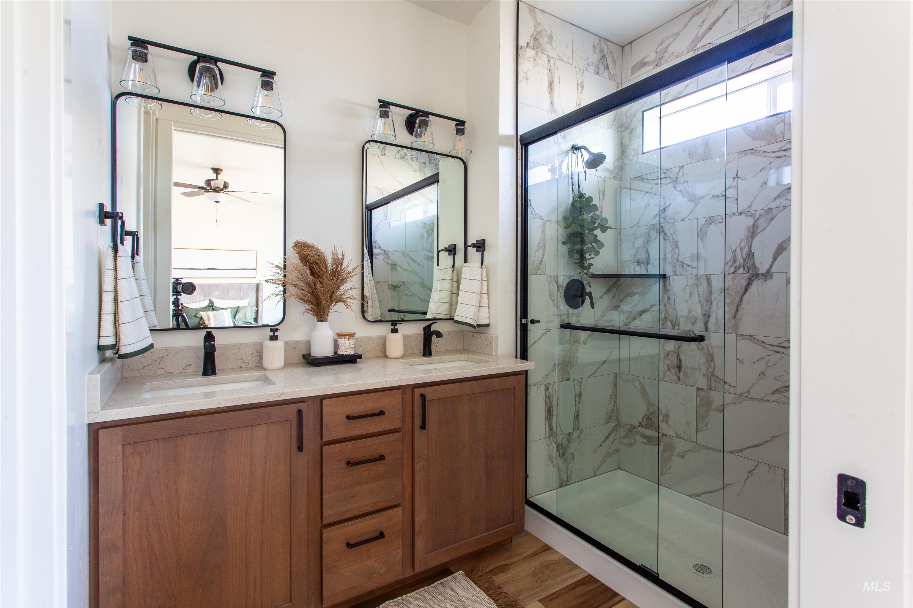 1113 Velvet Loop Wilder, ID 83676 - Photo 25 of 29 Bathroom with a marble finish shower, double vanity, light wood finished floors, and a ceiling fan