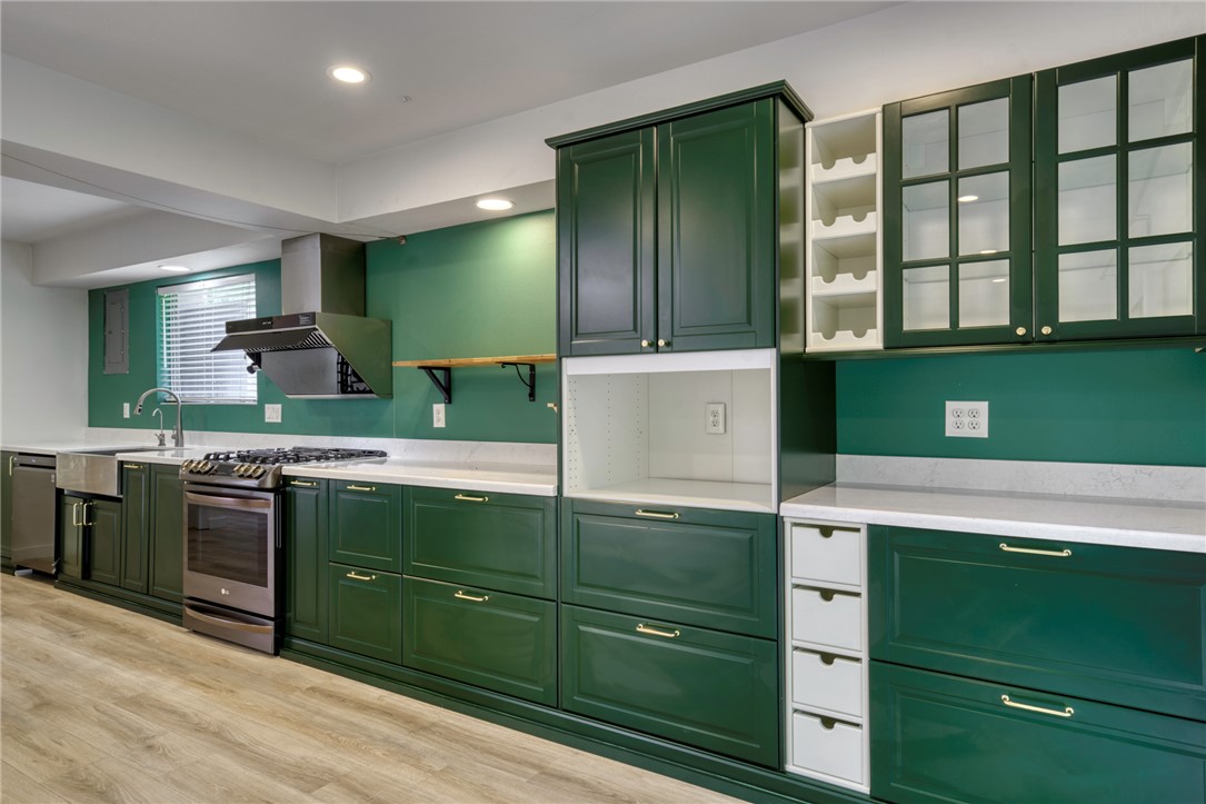 1513 Wolf Run College Station, TX 77840 - Photo 11 of 33 Kitchen featuring green cabinetry, open shelves, appliances with stainless steel finishes, light wood-type flooring, and recessed lighting