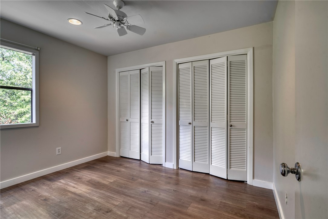 1513 Wolf Run College Station, TX 77840 - Photo 23 of 33 Unfurnished bedroom with multiple closets, dark wood-type flooring, and ceiling fan