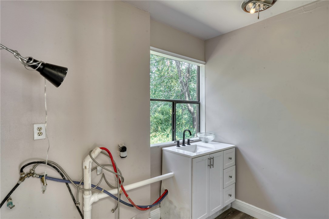1513 Wolf Run College Station, TX 77840 - Photo 25 of 33 Laundry room featuring a sink and dark wood-look flooring