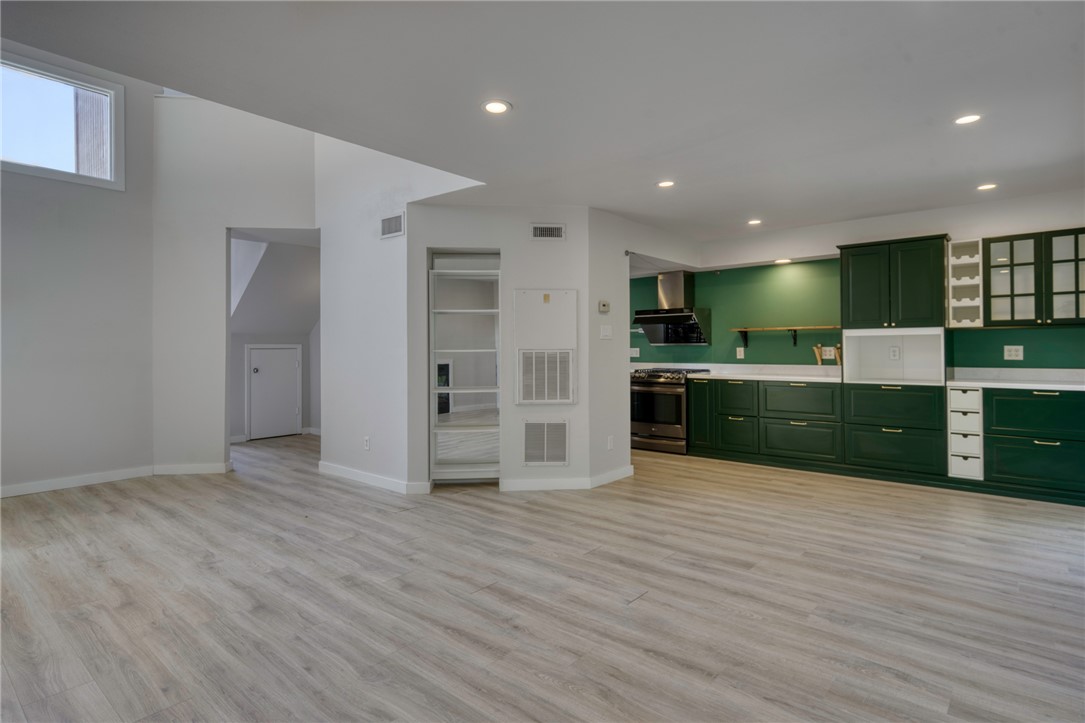 1513 Wolf Run College Station, TX 77840 - Photo 10 of 33 Kitchen with green cabinetry, light wood finished floors, stainless steel range with gas stovetop, light countertops, and recessed lighting
