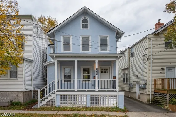 a view of a white house with large windows and a small yard