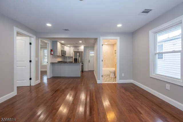 a view of a kitchen with wooden floor and a window