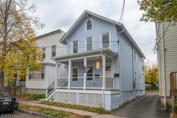 a view of a white house with large windows and a small yard