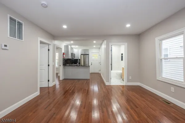 a view of a big room with wooden floor and windows