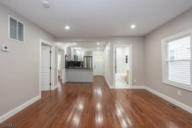 a view of a big room with wooden floor and windows