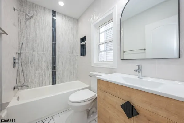 a bathroom with a sink a toilet a window and a bathtub