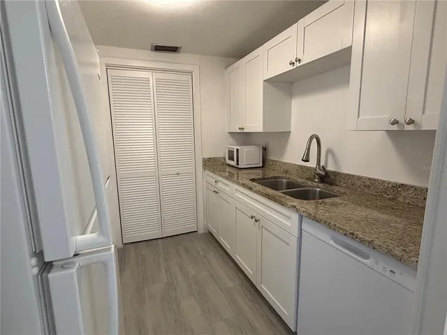 a kitchen with a refrigerator stove and white cabinets