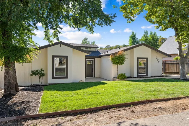 a front view of a house with a yard and garage
