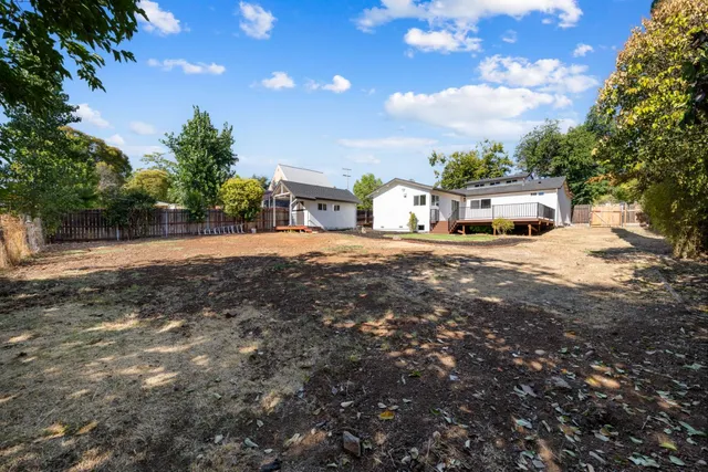 a view of a house with backyard and sitting area